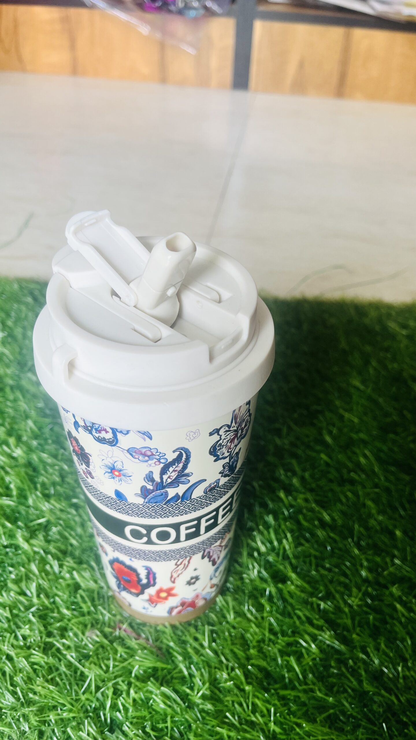 floral insulated travel coffee mug with flip straw & carry strap (430 500 ml) Flat lay of stainless steel floral travel mug interior beside detached lid, reusable straw, and wrist strap